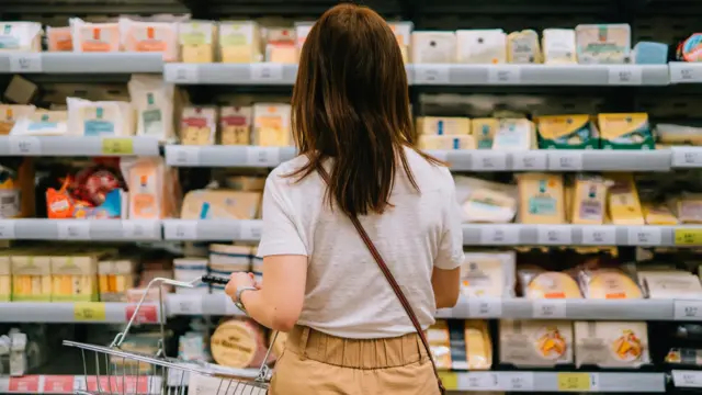 A file photo of a woman in a shop holding a basket