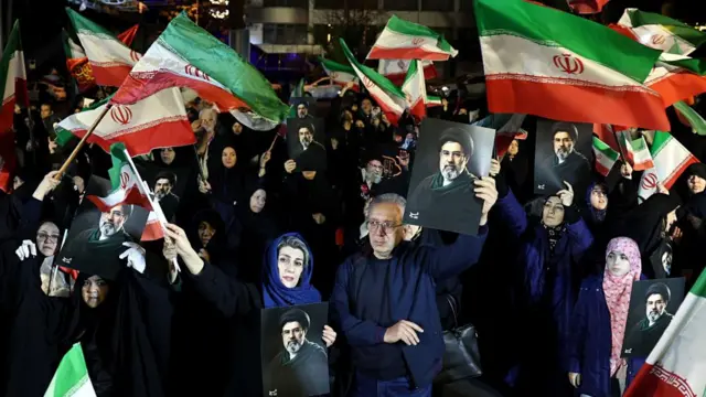 Iranian people chant, wave flags and hold posters of the new Iranian supreme leader Mojtaba Khamenei during a rally in support for the military, in Tehran