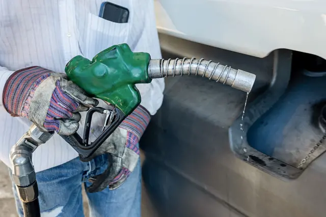 A driver refuels a tractor trailer with diesel.