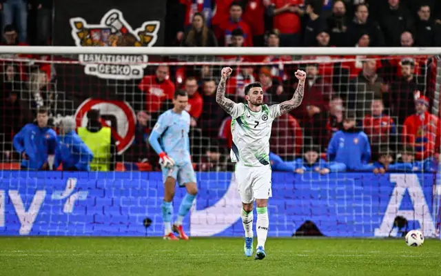 Parrott throws his arms up in celebration towards the away end