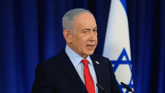 A file photo of Netanyahu standing at a podium in front of the Israeli flag
