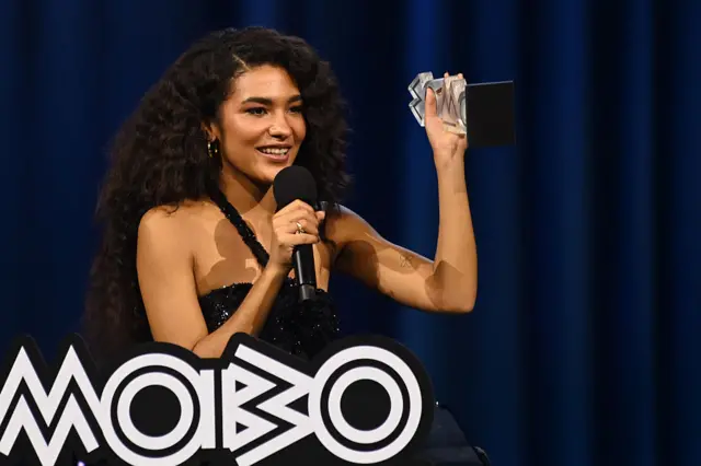 Dean holding up her Mobo award on stage