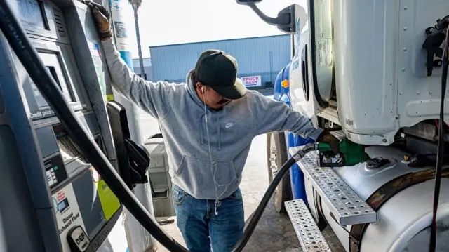 A driver refuels a lorry.