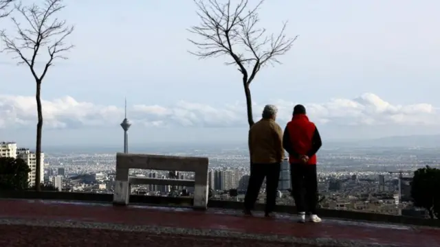 People stand at a park in view of Milad Tower, Tehran, on Wednesday