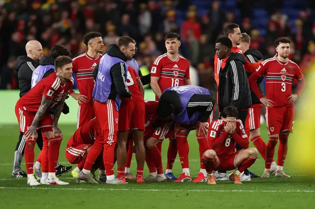 Wales players sink after losing the shootout