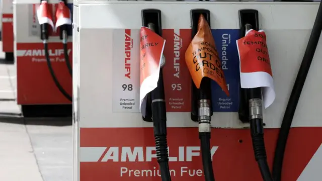 'Out of order' signs are displayed on empty fuel pumps at an Ampol petrol station after it ran out of fuel in Sydney
