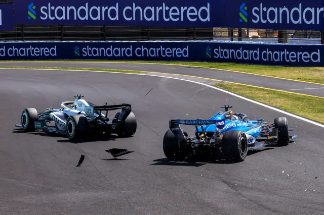 Debris flies off the Williams of Alex Albon after he collided with Cadillac's Sergio Perez at the chicane at Suzuka in Japanese Grand Prix first practice