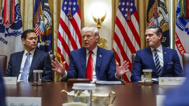 President Trump (c) speaking at a cabinet meeting in the White House on 26 March - he is flanked by Secretary of State Marco Rubio (l) and Defence Secretary Pete Hegseth (r)