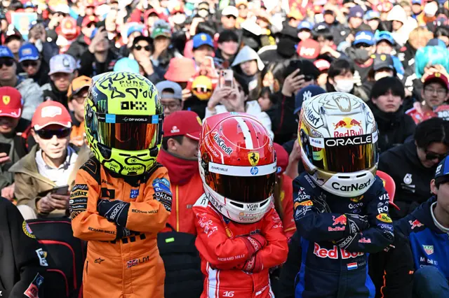 Three young fans dressed in full race suits as Lando Norris, Charles Leclerc and Max Verstappen