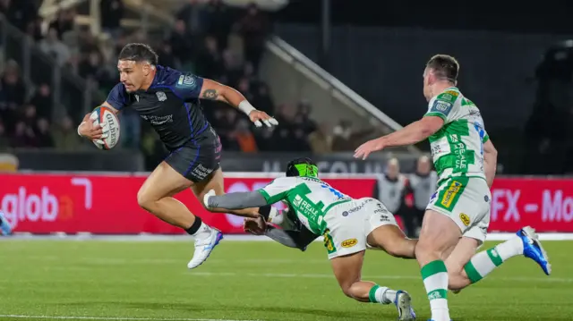 Sione Tuipulotu of Glasgow Warriors beats a tackle from Niccolo Cannone of Benetton