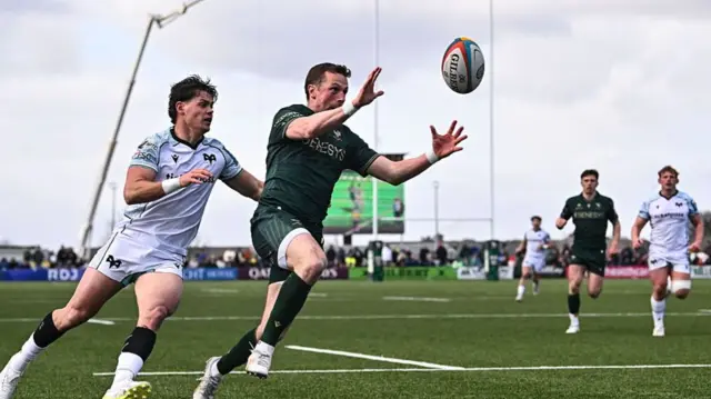 Jack Carty of Connacht beats Jack Walsh of Ospreys to the ball