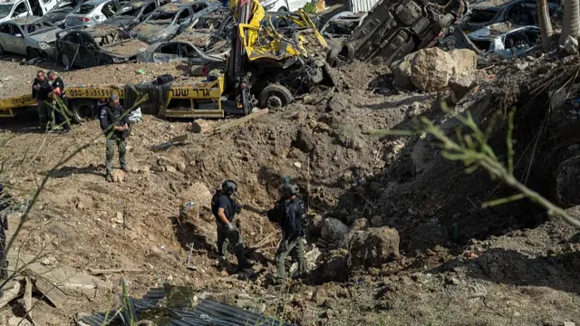 First responders gather near a crater left by an Iranian missile on March 28, 2026 in Beit Shemesh, Israel.