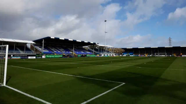 Barrow's Holker Street ground before kick-off against Bromley with blue sky and clouds above the stadium