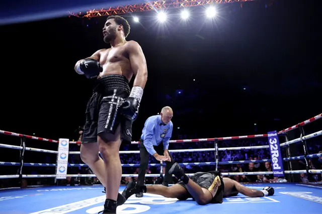 Moses Itauma celebrates with Jermaine Franklin on the canvas behind him