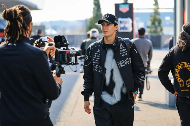 George Russell us filmed as he walks into the paddock
