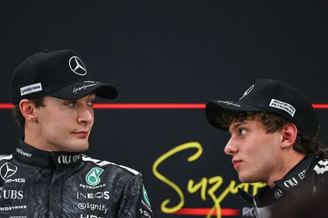 George Russell and Kimi Antonelli look at each other in the post-qualifying news conference