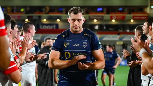 Ben Carter leads the Dragons off after defeat by Ulster in Belfast