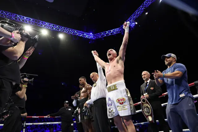 Willy Hutchinson has his arm raised in the ring