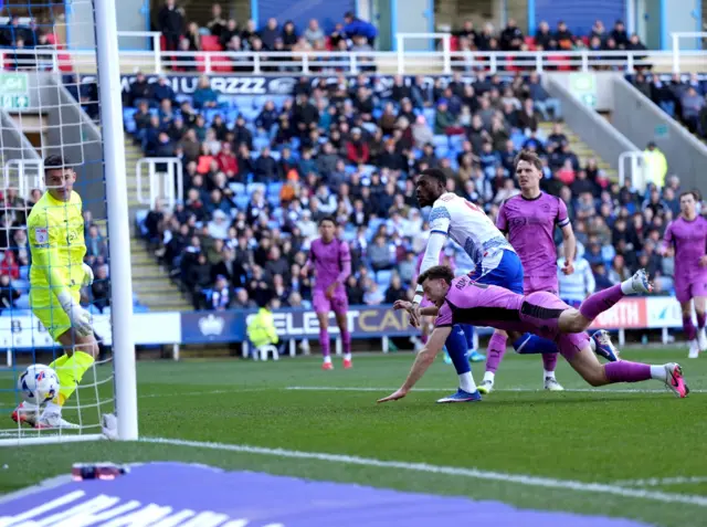 Reading's Kelvin Ehibhatiomhan (centre) scores their first goal despite the efforts of Wigan Athletic's Will Aimso
