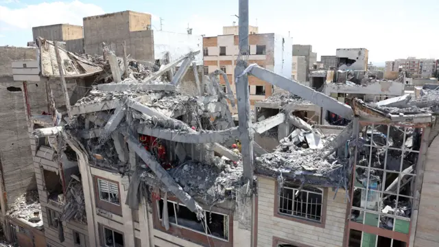 Iranian firefighters work on a damaged residential building in southern Tehran, Iran, 27 March 2026.