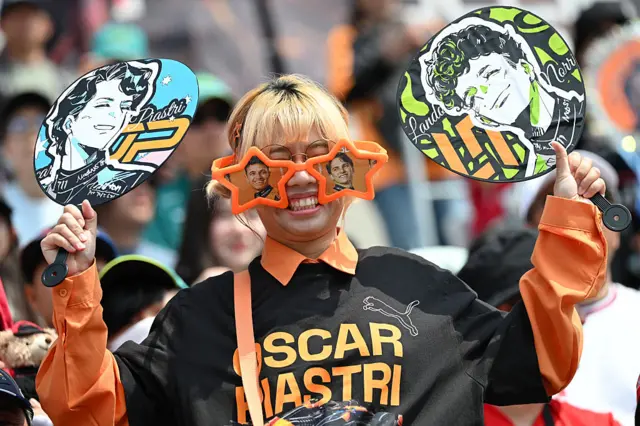 A fan holds up signs for Oscar Piastri and Lando Norris