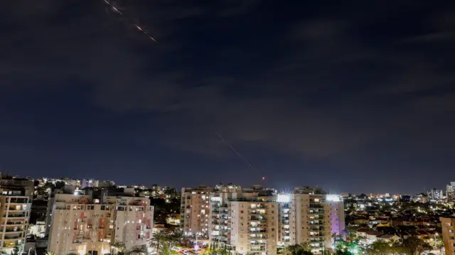 Streaks of light illuminate the sky during an interception attempt, amid the US-Israeli conflict with Iran, as seen from Ashkelon, Israel, 28 March 2026.
