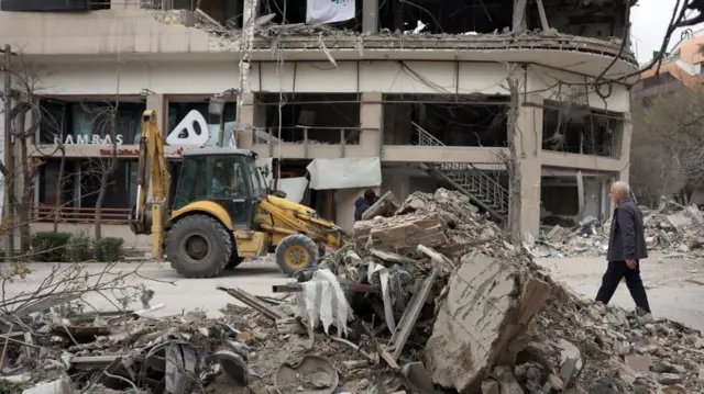 Truck woks to remove rubble at destroyed buildings near the Qatari Al Araby TV office