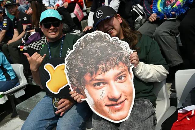 A fan holds a bif Kimi Antonelli head