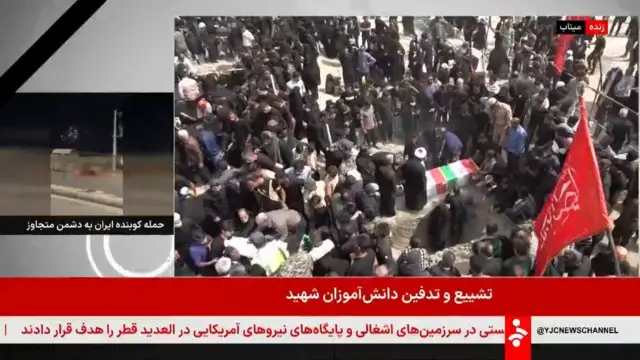 A screenshot of the Iranian state TV broadcast, it shows dozens of people in black standing around newly dug graves