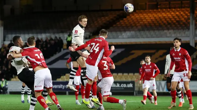 Ben Waine (centre) jumps in the air as the ball flies towards goal and Bristol City players stand watching