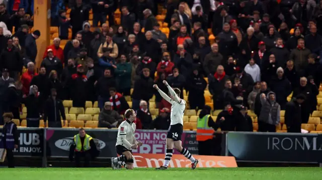 Ben Waine (left) kneels on the floor as team-mate Kyle John (right) runs up to him with his arms in the air