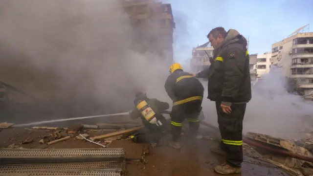 Three fire fighters put out a fire in a residential area in Beirut