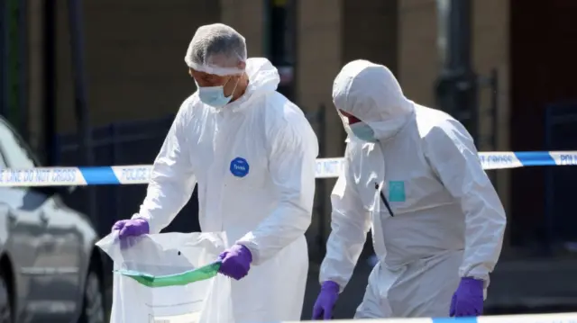 Forensics carrying a plastic bag