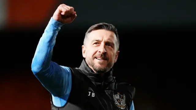 John Brady holds his fist in the air and smiles