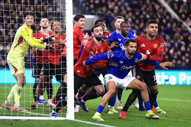 Iliman Ndiaye of Everton holds back Bruno Fernandes and Casemiro of Manchester United as players jostle at a corner kick d