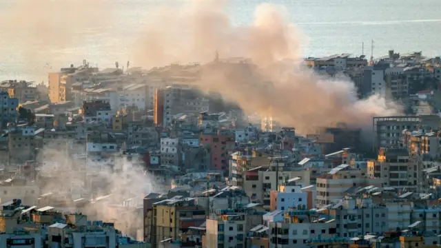 smoke rising from densely packed buildings in a city