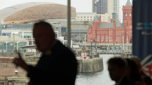 Silhouette of Darren Millar in front of Cardiff Bay