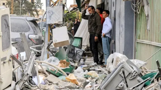 People look on at the site of a damaged building following a targeted Israeli strike, amid escalating hostilities between Israel and Hezbollah, as the U.S.-Israel conflict with Iran continues, Lebanon, March 30, 2026.