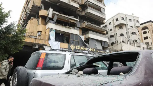A person walks past a damaged building following a targeted Israeli strike, amid escalating hostilities between Israel and Hezbollah, as the U.S.-Israel conflict with Iran continues, Lebanon, March 30, 2026