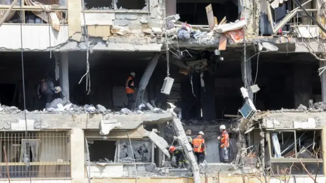 Rescue workers at a damaged building following a targeted Israeli strike, amid escalating hostilities between Israel and Hezbollah, as the U.S.-Israel conflict with Iran continues, Lebanon, March 30, 2026