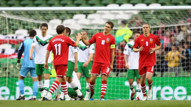 With a backdrop of empty seats at the Aviva Stadium, Aaron Ramsey is congratulated after scoring for Wales against Northern Ireland in 2011