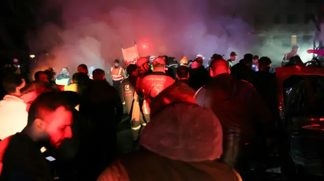 First responders rush to the site of a series of Israeli strikes in Jnah