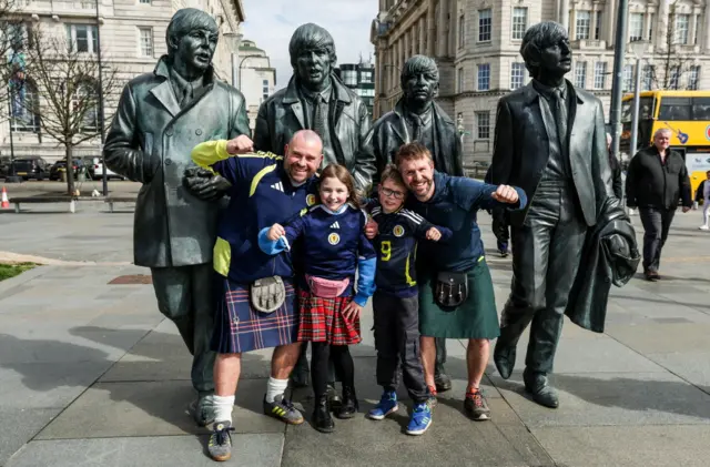 Scotland fans pose by The Beatles statue in Liverpool