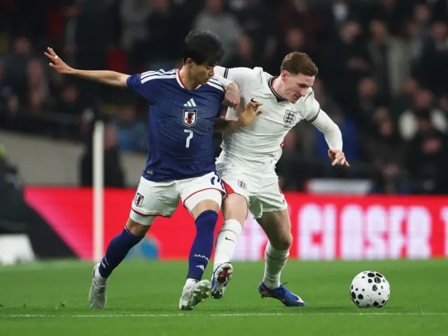 Japan's Kaoru Mitoma in action with England's Elliot Anderson
