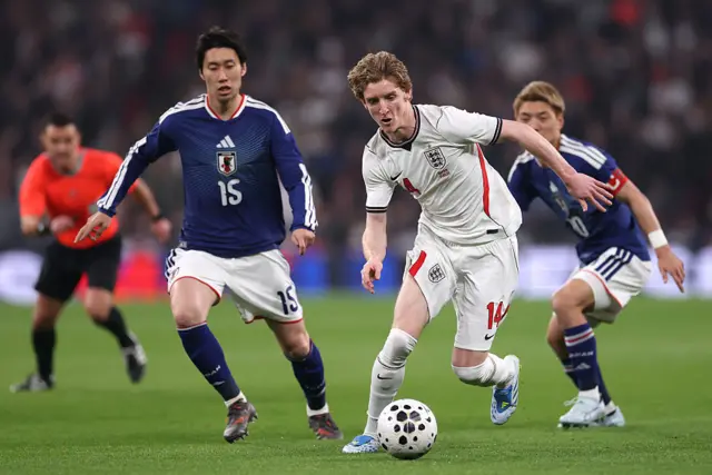 Anthony Gordon of England runs with the ball whilst under pressure from Daichi Kamada of Japan during the international friendly match between England and Japan at Wembley Stadium on March 31, 2026 in London, England.