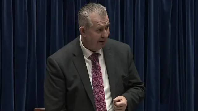 Edwin poots stands now as the speaker, addressing the Assembly