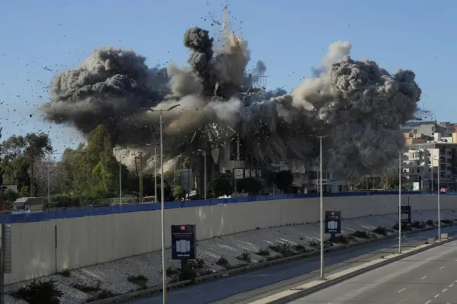 Another angle shows an explosion at a residential building, showing smoke billowing in all directions from the building. A deserted road is shown in the foreground.
