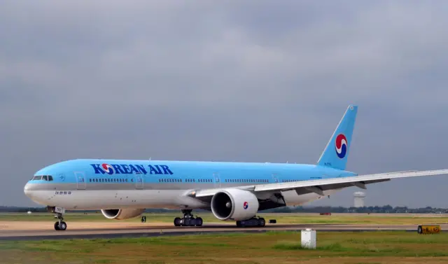 A Korean Air Boeing 777 passenger jet taxis for take-off at an airport