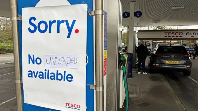 A sign telling motorists that there is no unleaded petrol available at some of the fuel pumps is displayed at a Tesco supermarket petrol station