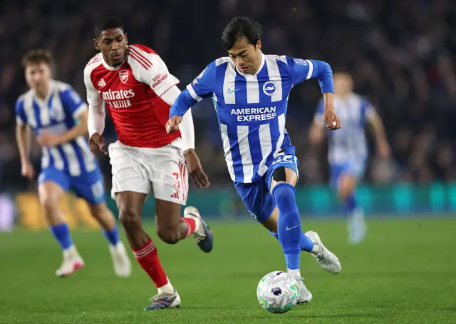 Kaoru Mitoma of Brighton & Hove Albion runs with the ball whilst under pressure from Cristhian Mosquera of Arsenal